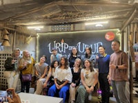 a group of people posing for a picture in front of a sign