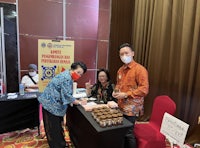 a group of people standing at a table with food in front of them