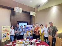 a group of people posing for a picture in front of a table