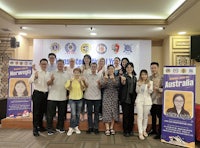 a group of people posing for a picture in front of a banner