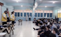 a group of people sitting on the floor in a classroom