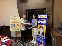 a man and a woman standing next to each other in front of a table